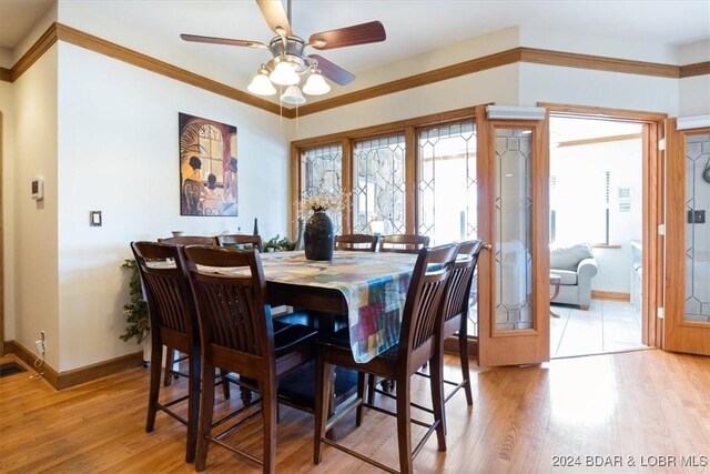 dining space featuring ceiling fan, light hardwood / wood-style floors, and crown molding