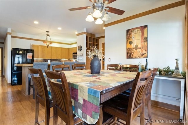 dining room with ceiling fan, crown molding, and light hardwood / wood-style flooring