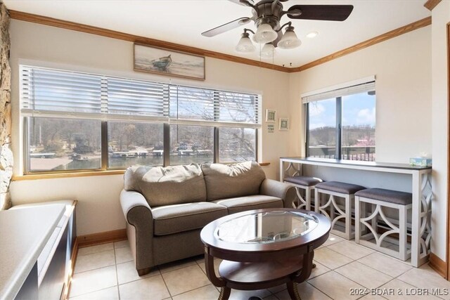 living room with ceiling fan, light tile patterned flooring, and ornamental molding