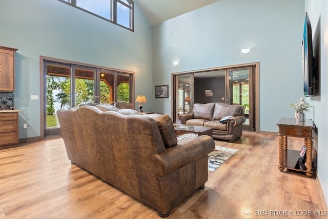 living room with light hardwood / wood-style flooring and high vaulted ceiling