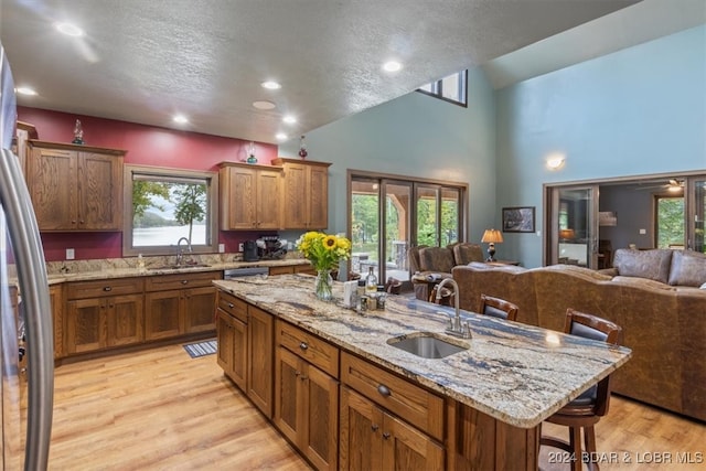 kitchen featuring a breakfast bar area, sink, an island with sink, and plenty of natural light