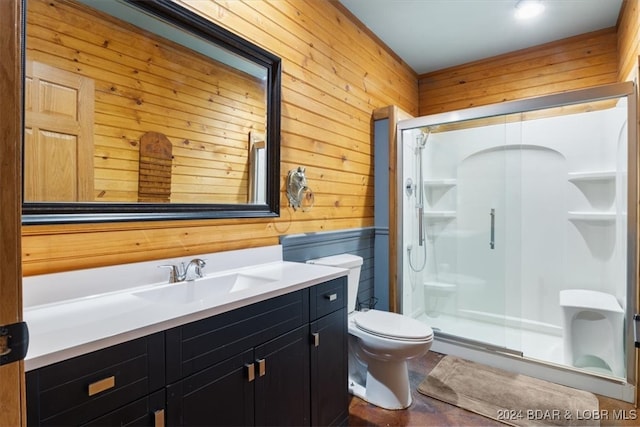 bathroom with vanity, wooden walls, toilet, and an enclosed shower