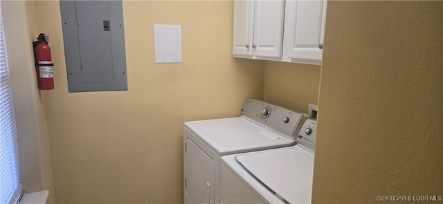 clothes washing area featuring cabinets, electric panel, and separate washer and dryer