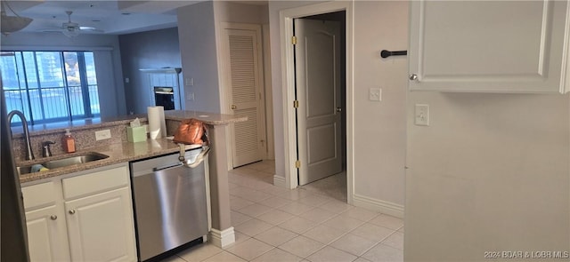 kitchen with stainless steel dishwasher, ceiling fan, sink, white cabinets, and light tile patterned flooring