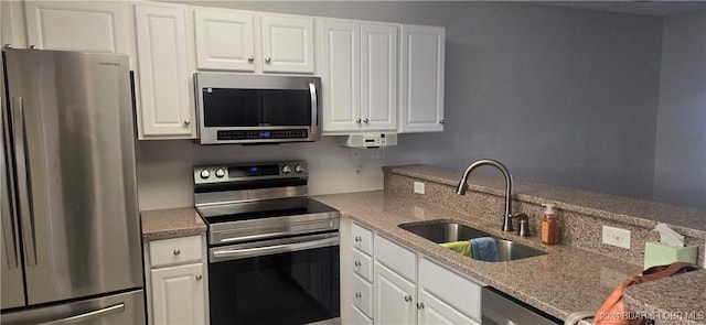 kitchen featuring sink, white cabinets, and appliances with stainless steel finishes