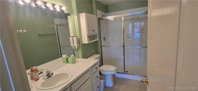 bathroom with toilet, vanity, tile patterned floors, and a shower with door