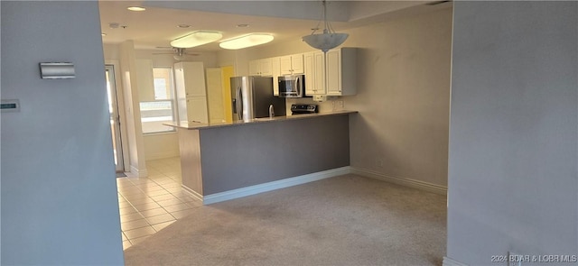 kitchen featuring light colored carpet, white cabinetry, kitchen peninsula, and appliances with stainless steel finishes