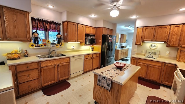 kitchen with ceiling fan, a kitchen island, white appliances, and sink