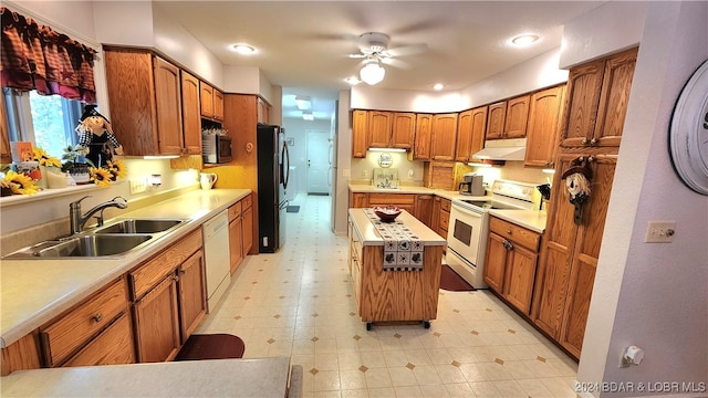 kitchen featuring ceiling fan, sink, a kitchen island, and white appliances