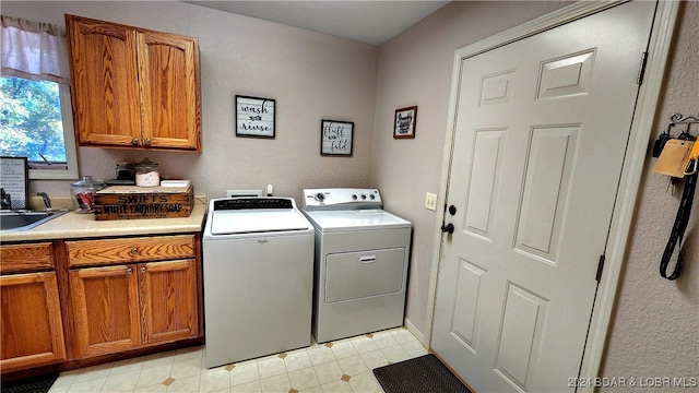 clothes washing area featuring cabinets and independent washer and dryer