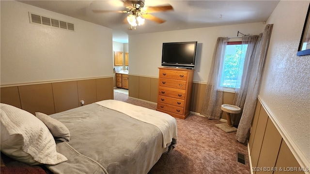 bedroom featuring carpet flooring, ensuite bathroom, and ceiling fan