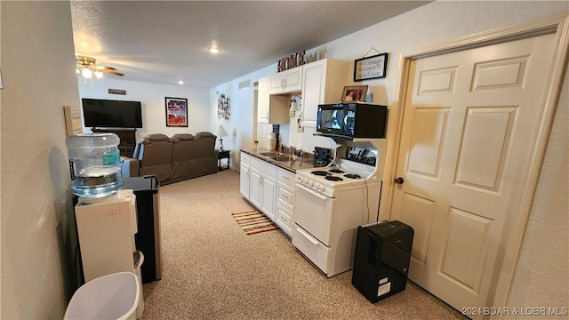 kitchen with a textured ceiling, light colored carpet, white range with electric stovetop, ceiling fan, and white cabinets