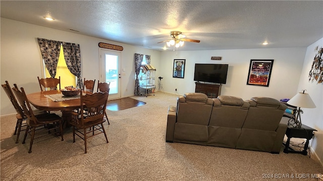 carpeted living room with ceiling fan and a textured ceiling