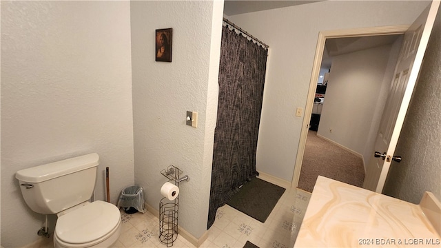 bathroom featuring vanity, curtained shower, and toilet