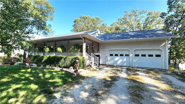 view of front facade featuring a porch, a garage, and a front yard