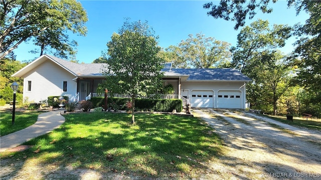 single story home with a porch, a garage, and a front lawn