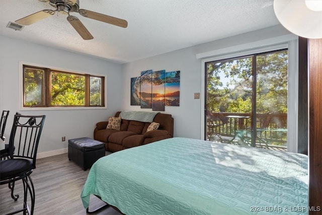 bedroom featuring a textured ceiling, access to outside, light hardwood / wood-style flooring, and ceiling fan