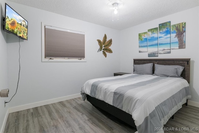 bedroom with wood-type flooring and a textured ceiling