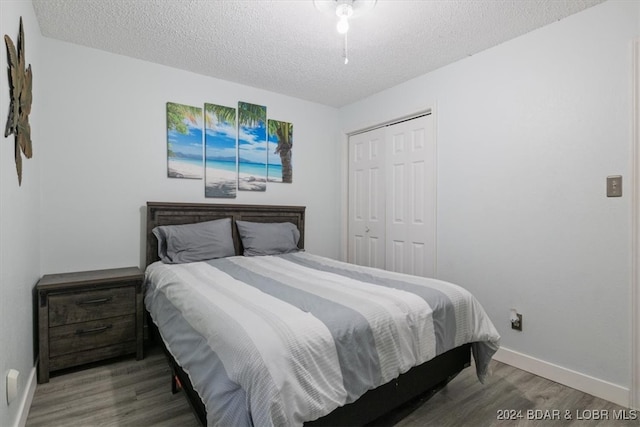 bedroom with wood-type flooring, a textured ceiling, and a closet