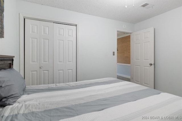 bedroom with a textured ceiling and a closet