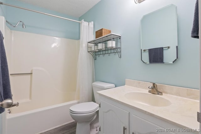 full bathroom with shower / bath combination with curtain, vanity, a textured ceiling, hardwood / wood-style flooring, and toilet