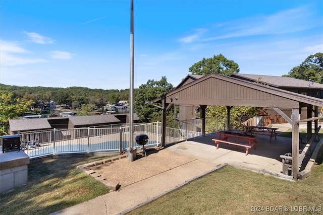 view of property's community featuring a lawn, a gazebo, a pool, and a patio