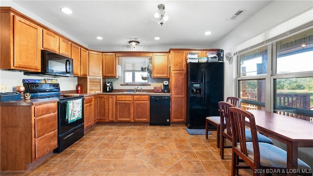 kitchen featuring light tile patterned floors, plenty of natural light, sink, and black appliances