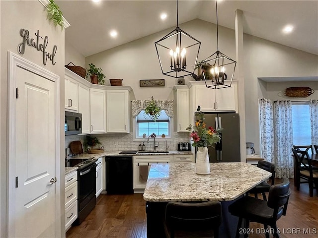 kitchen featuring sink, hanging light fixtures, appliances with stainless steel finishes, a kitchen island, and white cabinets