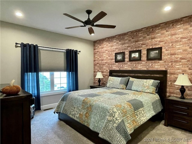 bedroom with light carpet, ceiling fan, and brick wall