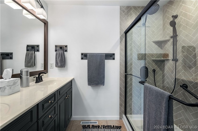 bathroom with tile patterned flooring, vanity, and walk in shower