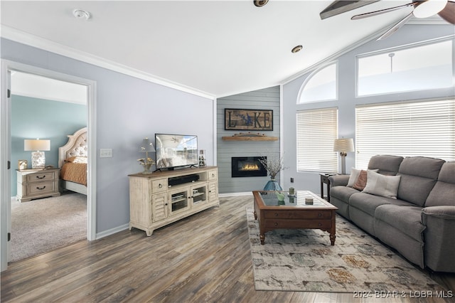 living room featuring ornamental molding, lofted ceiling, a large fireplace, and hardwood / wood-style floors