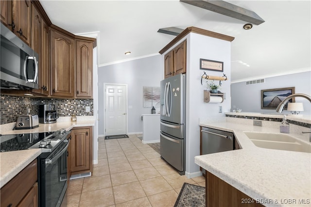 kitchen featuring sink, crown molding, light tile patterned floors, stainless steel appliances, and decorative backsplash