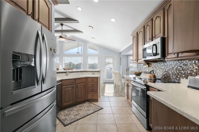 kitchen featuring light tile patterned flooring, sink, tasteful backsplash, lofted ceiling with beams, and appliances with stainless steel finishes