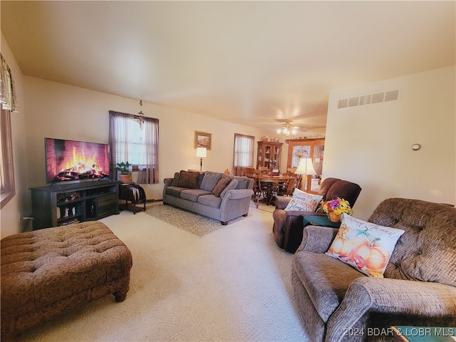 carpeted living room with ceiling fan