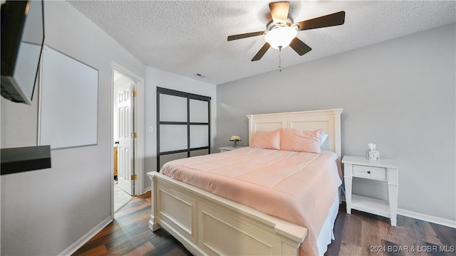 bedroom featuring ceiling fan, a textured ceiling, and dark hardwood / wood-style flooring