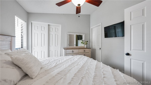 bedroom featuring ceiling fan, a textured ceiling, and lofted ceiling