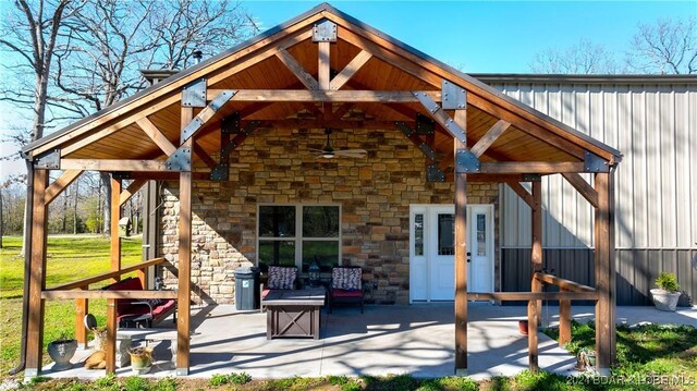 1251 Carnahan Rd, Macks Creek, MO 65786 - back of property featuring stone siding, a patio, a ceiling fan, and board and batten siding