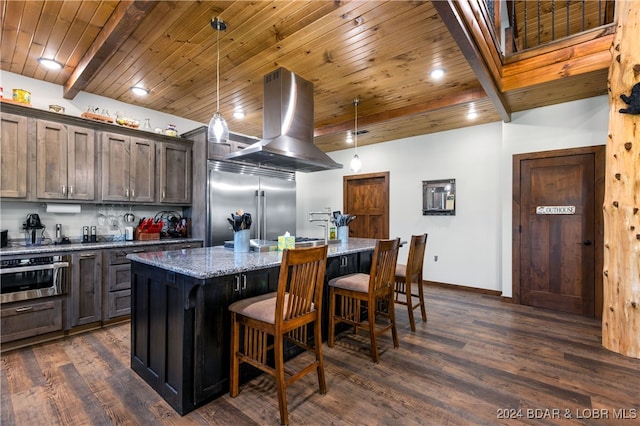 kitchen with stainless steel appliances, light stone counters, hanging light fixtures, island exhaust hood, and a kitchen island