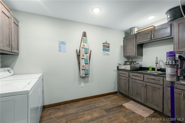 laundry room featuring dark wood-type flooring, cabinets, sink, and washer and dryer