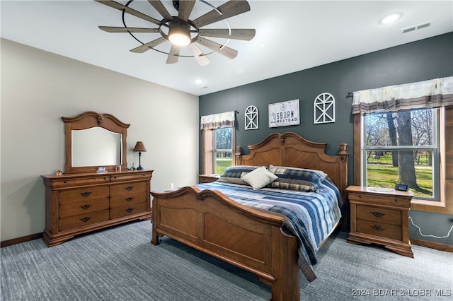 carpeted bedroom with multiple windows and ceiling fan