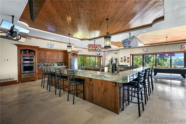 kitchen with wooden ceiling, pendant lighting, and light stone counters