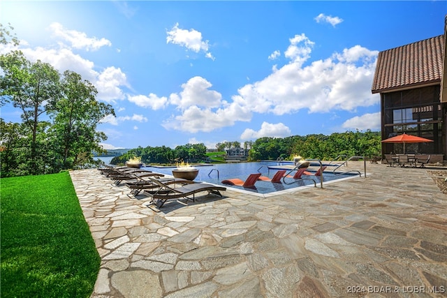 view of pool with a patio area and a water view