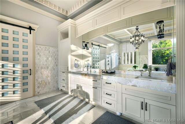 bathroom with beam ceiling, coffered ceiling, a notable chandelier, vanity, and ornamental molding