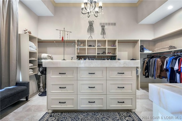 spacious closet featuring a notable chandelier