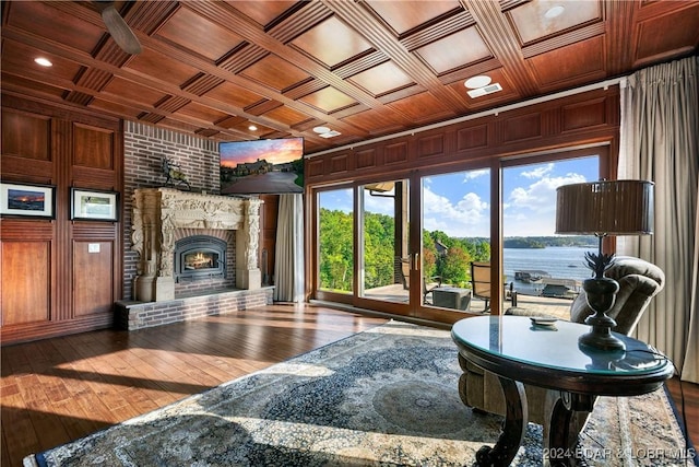 living room featuring coffered ceiling, wood ceiling, a brick fireplace, and wood-type flooring