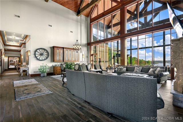 living room with beamed ceiling, dark hardwood / wood-style floors, high vaulted ceiling, and a chandelier