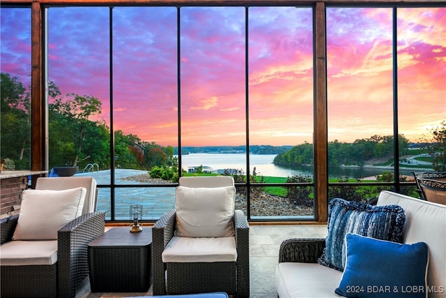 sunroom featuring a water view