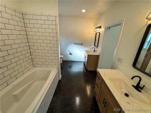 full bathroom with toilet, two vanities, a sink, marble finish floor, and tiled tub