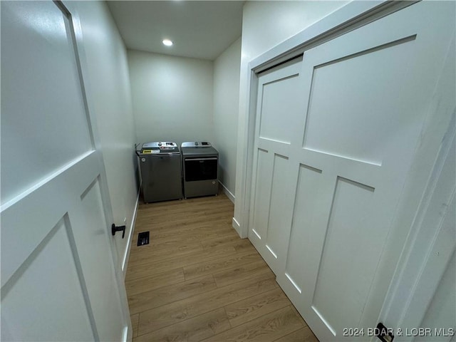 hall with light wood-type flooring, washer and clothes dryer, baseboards, and recessed lighting