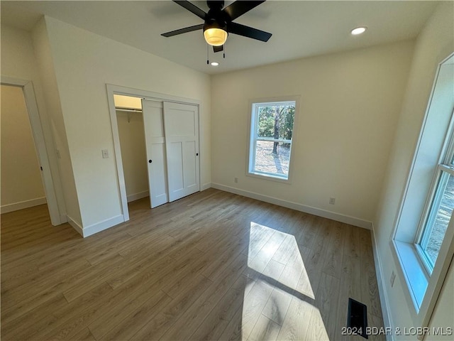 unfurnished bedroom with recessed lighting, a closet, baseboards, and light wood finished floors